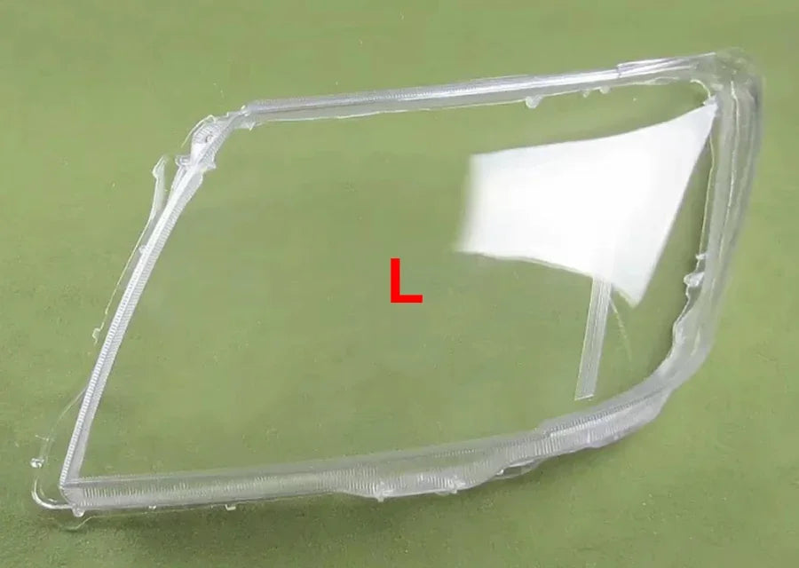 Clear car headlight cover with 'L' marking on a green background