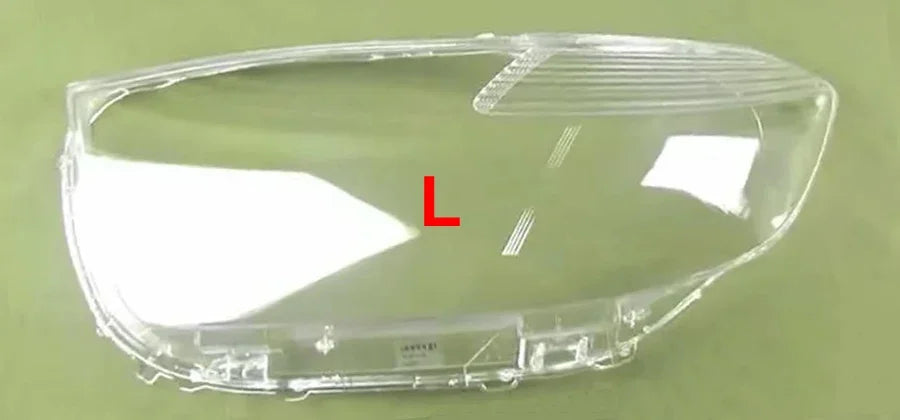 Clear car headlight cover with 'L' marking on a green background