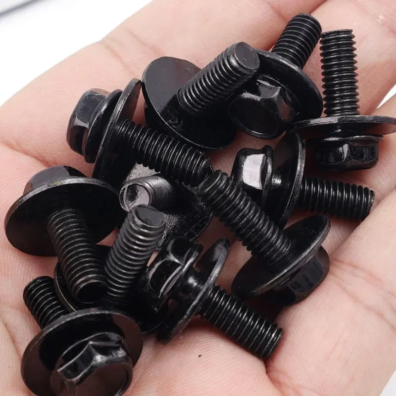Hand holding a collection of black screws