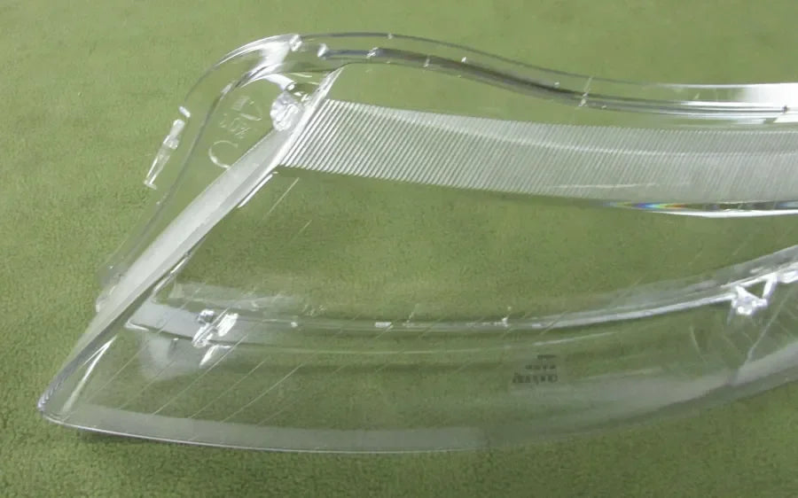 Clear plastic car headlight cover on a green background