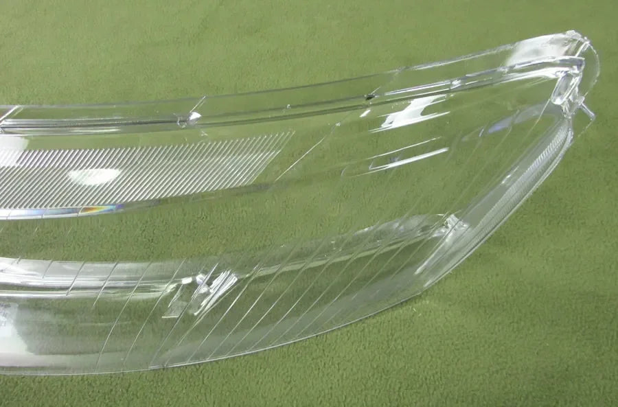 Clear car headlight cover on a green background