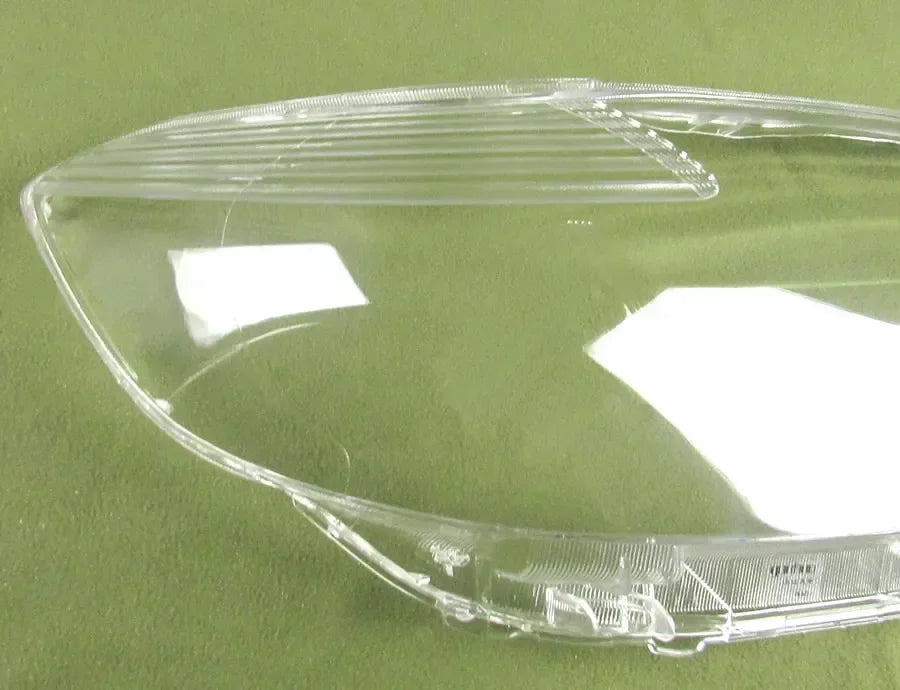 Clear plastic car headlight cover on a green background
