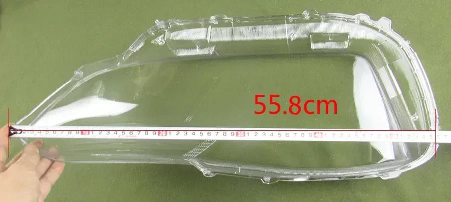 Clear car headlight cover with measurement on a green background