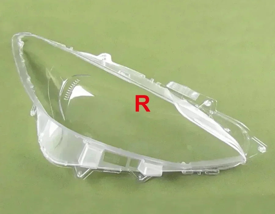 Clear car headlight cover with 'R' marking on a green background