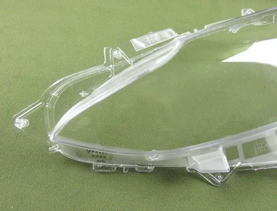Clear plastic car headlight cover on a green background