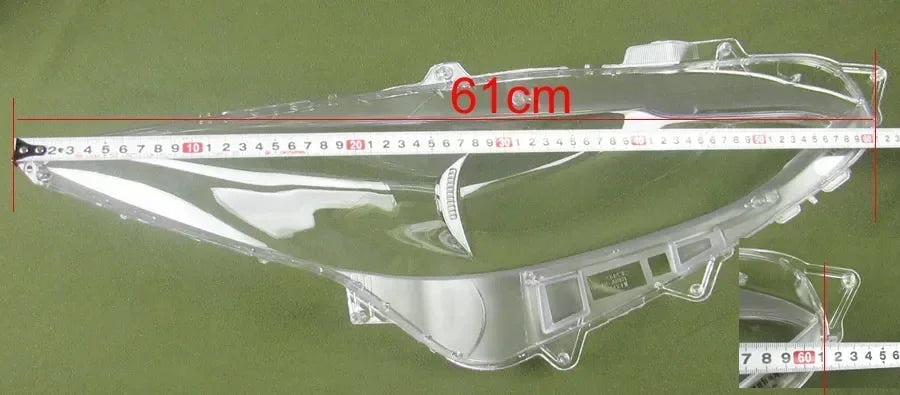 Clear motorcycle fairing with a ruler indicating dimensions on a green background