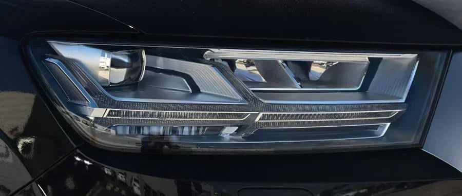 Close-up of a car headlight with a shiny metallic finish.