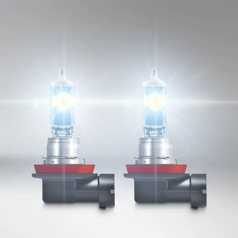 Two car headlights with red reflectors on a gray background