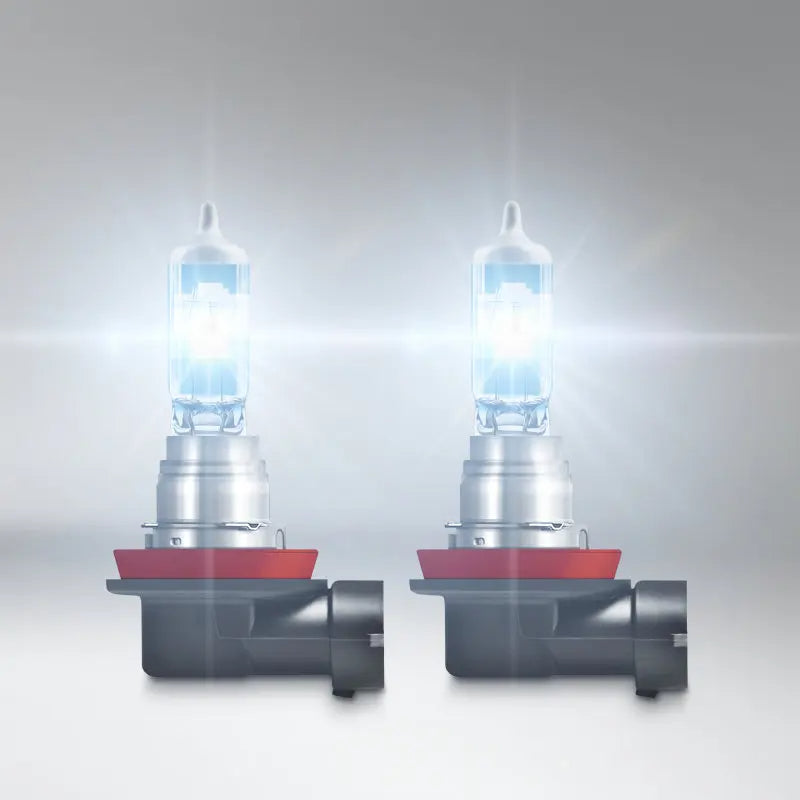 Two car headlights with clear glass covers on a gray background