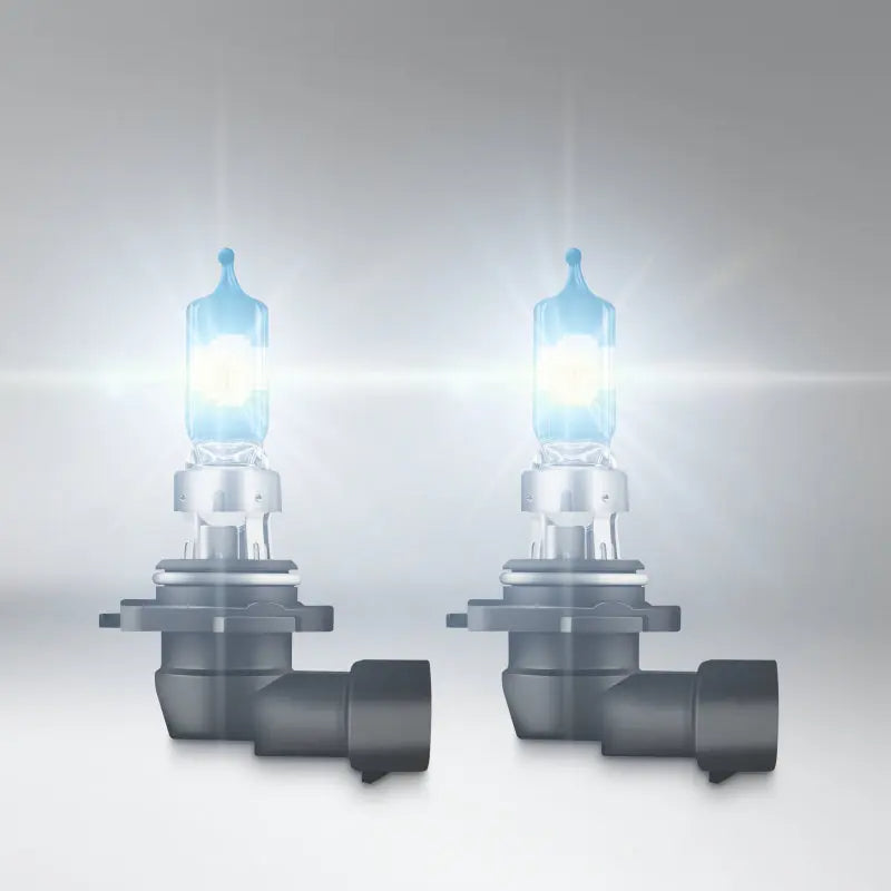 Two car headlights with blue glow on a gray background