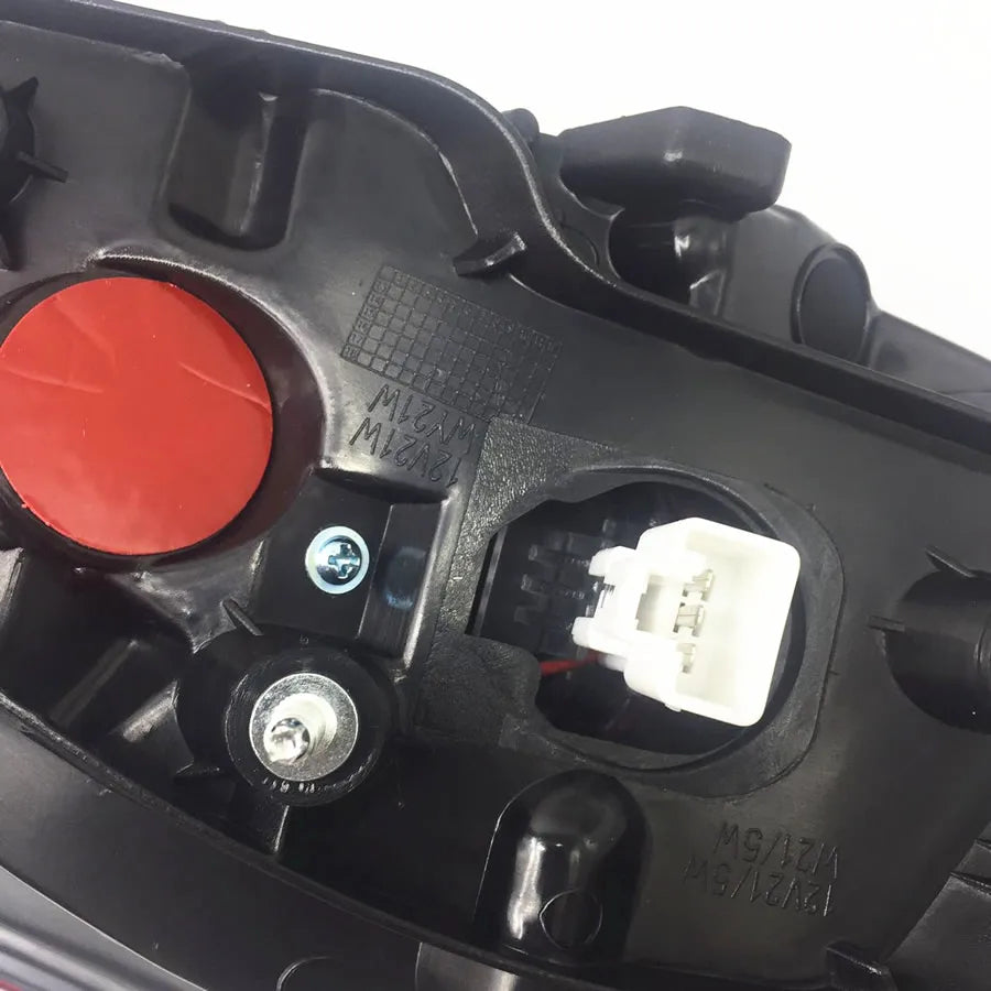 Close-up of a mechanical component with a red button and wiring on a white background