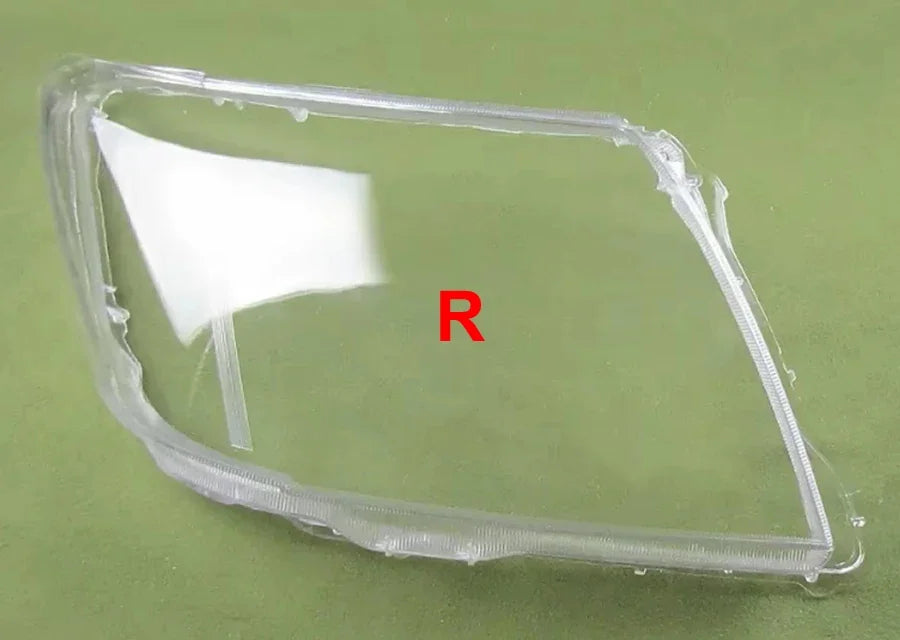 Clear car headlight cover with 'R' marking on a green background