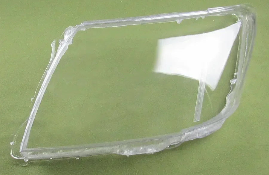 Clear plastic car headlight cover on a green background
