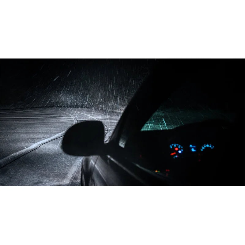Car interior at night with dashboard lights on a snowy road